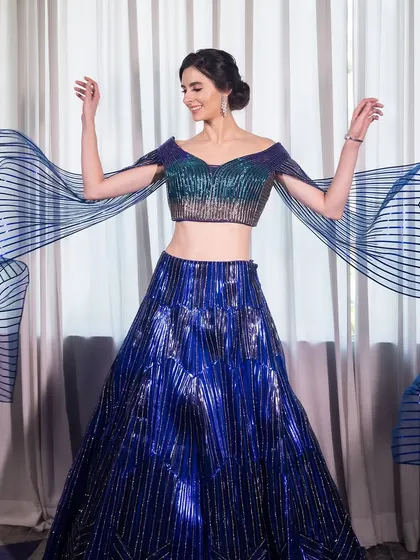 The dramatic, flowing sleeves of the lehenga add a touch of playfulness to this high-fashion look.