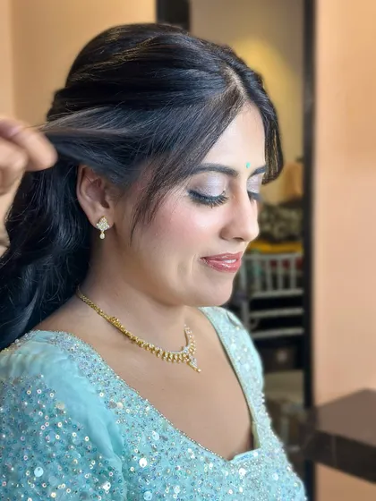 A side profile showcasing the soft, blended eye makeup and the elegant half-up hairstyle. This look is all about understated glamour.