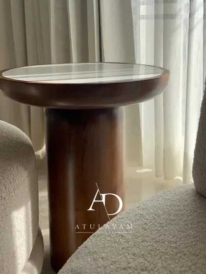 A unique round side table made of rubberwood with a stone top, showcasing an alternative to standard furniture.