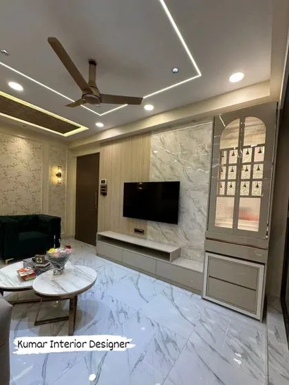 A completed living room project at Raymond Realty, Thane. This shows the final look with a TV unit, pooja unit, and elegant false ceiling lighting.