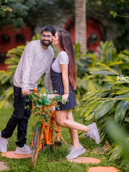 A sweet kiss on the cheek next to a bicycle. This candid moment is full of love and shows the fun, relaxed dynamic of the couple.