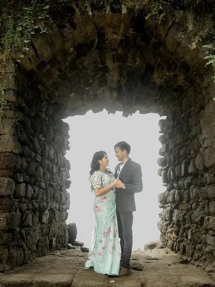 A beautiful portrait framed by a rustic stone archway, with ivy adding a touch of natural romance to the historic setting.