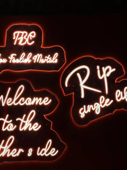 Neon signs are a fantastic way to set the mood. For this "RIP Single Life" party, we used cheeky and bold signs like 'Welcome to the other side' to create a fun, edgy atmosphere that was perfect for a pre-wedding cocktail night.