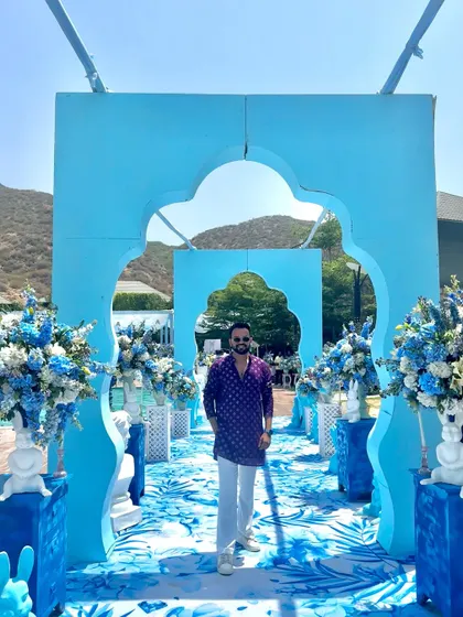 A moment of calm before the storm. Posing at the entrance of a beautifully decorated blue-themed wedding carnival, ready to bring the energy.
