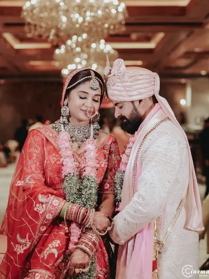 A quiet, romantic moment between the couple after their Varmala ceremony. The soft lighting and their close posture convey deep intimacy.