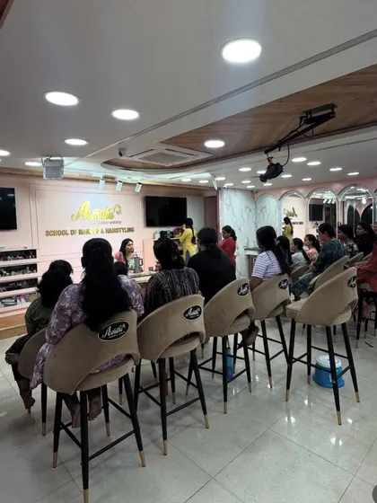 The view from the back of the classroom during a professional makeup course. Every student is engaged and focused on the lesson.
