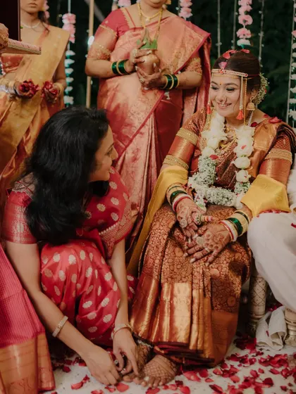 A touching moment between the bride and a family member during a wedding ritual. These inter-family connections are a beautiful part of any wedding story.