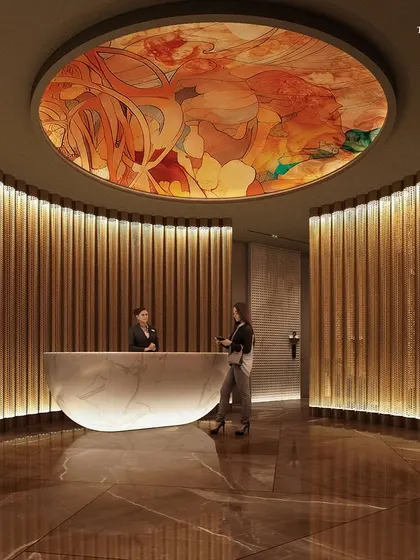 The reception desk at Palais Royale, set against a backdrop of warm, fluted wood panels. A custom art installation on the ceiling adds a dramatic touch, reinforcing the ethos of grand hospitality and sophistication.