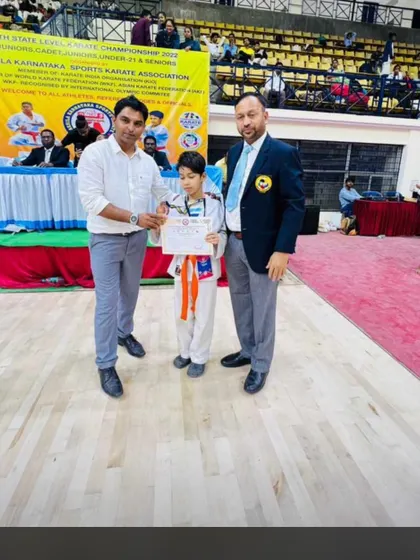 A student receiving his certificate and medal at the 13th State Level Karate Championship.