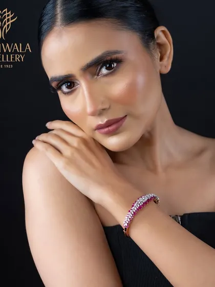 A vibrant bracelet featuring a line of rubies bordered by diamonds. This piece is perfect for adding a pop of color and a touch of festive glamour to any ensemble.