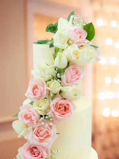 A close-up of the cascading fresh roses on our 'Forever in Full Bloom' cake. The combination of soft pink and cream roses with delicate baby's breath creates a lush, romantic texture.