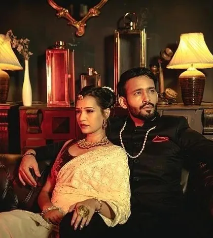 A vintage-themed pre-wedding shot, with the couple exuding old-world glamour in a richly decorated, dimly lit room.