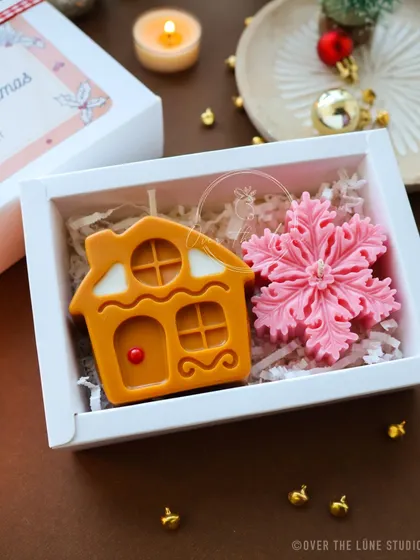 A lovely pink and orange themed Christmas gift box, featuring a gingerbread house and a pink snowflake candle. I love creating these unique color combinations.