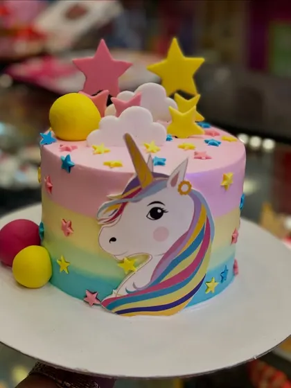 This unicorn cake features a pastel rainbow base and is decorated with fondant stars and clouds. The design is whimsical and dreamy, perfect for a magical birthday celebration.