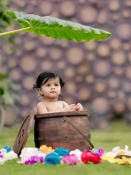 A sweet baby peeking out of a wooden barrel, surrounded by colorful flowers. We love creating these cute and whimsical scenes.