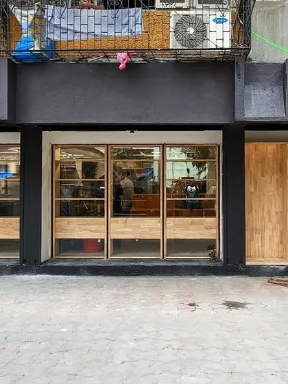The finished facade in daylight, showing the clean lines of the woodwork and the bold new signage.