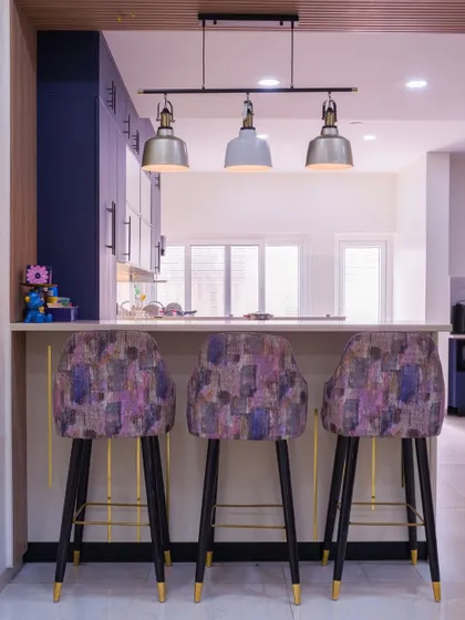 Brighten up your mornings with this colorful breakfast counter. The bold patterned stools and sleek pendant lights add a trendy, fun vibe to the kitchen space.