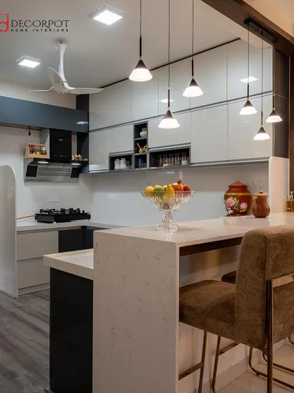 This U-shaped kitchen includes a breakfast bar with comfortable seating and stylish pendant lights. It's a smart design that creates a casual dining spot without needing a separate dining room.