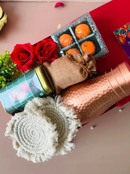An overhead view of the red flap-open box, showing the beautiful arrangement of a copper bottle and other eco-friendly items.