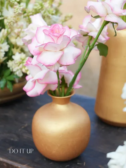 A single, perfect pink and white rose in a small golden vase. This highlights my belief that even the smallest floral detail can add a touch of beauty and intention to a space.