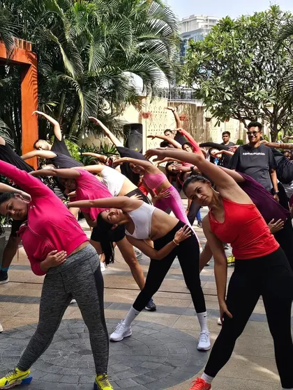 A dynamic side stretch during a warm-up. I ensure every session includes proper warm-ups and cool-downs to prevent injury and maximize benefits.