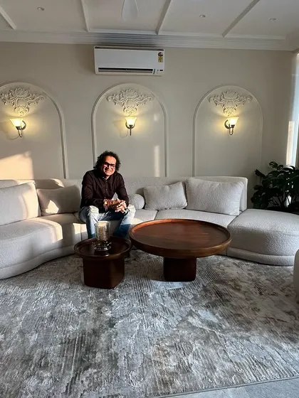 Taking a moment to enjoy the finished living room. The curved sofa and arched wall details create a space that is both elegant and comfortable.