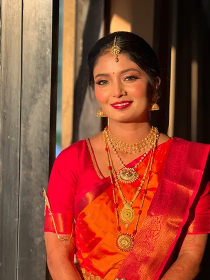 A happy and bright portrait of Raksha, her red lipstick perfectly matching her beautiful saree.