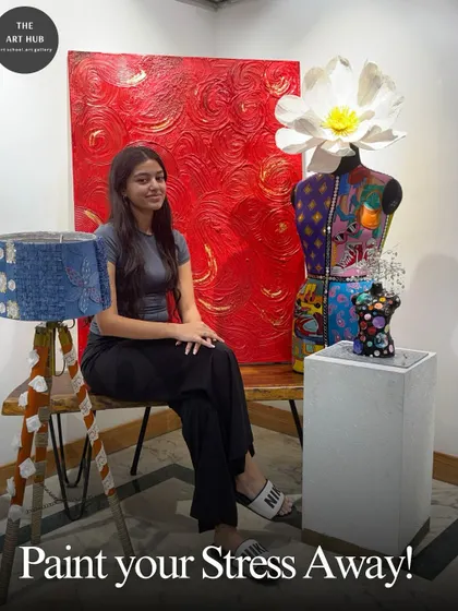 I encourage students to unwind and paint their stress away. This student is pictured with her creative projects, including a painted mannequin and a textured canvas, in our vibrant studio.