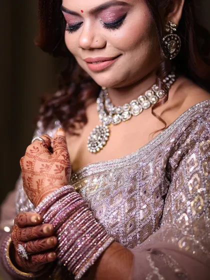 A detailed bridal portrait focusing on the bride's intricate henna, sparkling jewelry, and beautiful makeup before her engagement ceremony.