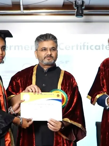 Handing a certificate to a female graduate. Empowering women through education is critical for the progress of our society.