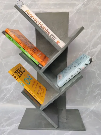 Our grey bookshelf is not just for show; it's a functional piece designed to hold your favorite books. Here it is, styled with titles like 'Atomic Habits' and 'Zero to One'.
