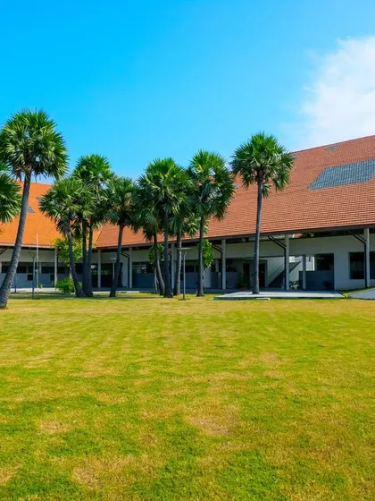 A duplicate image of the sports field and academic buildings at Vellore International School.