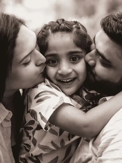 A beautiful black and white portrait showing a daughter showered with love from both her parents. This timeless image focuses purely on the emotion and connection within the family.