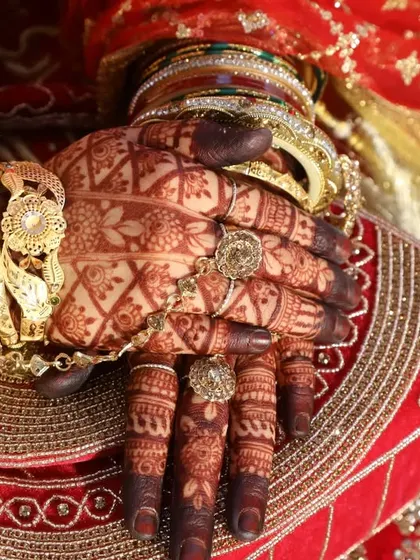 Another angle showing the deep, rich stain that complements the bride's traditional jewelry and outfit perfectly.