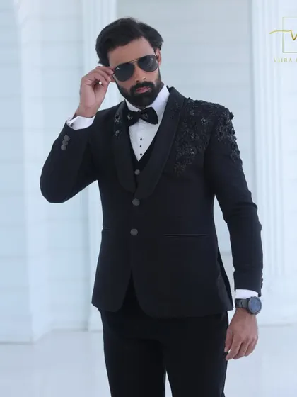 A close-up of the model wearing our black embroidered tuxedo. The fit across the shoulders and chest is a testament to our precise custom tailoring process.
