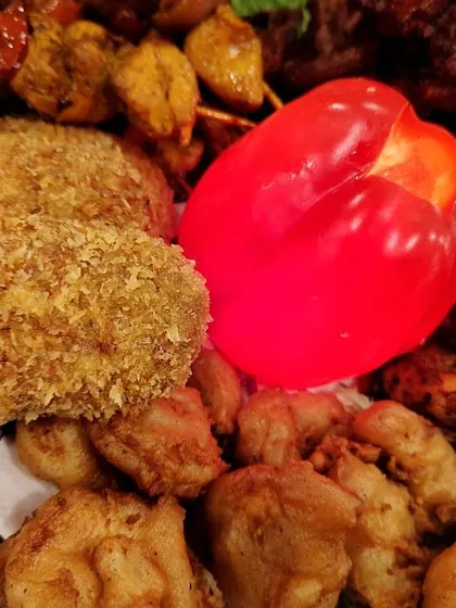 A detailed shot focusing on the crispy, golden-brown texture of our crumb-fried chicken cutlets and battered fish. It’s all about getting that perfect crunch.