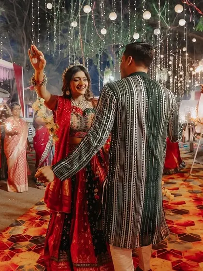 The couple makes a grand entrance to their Sangeet, walking through a pathway of guests holding sparklers.