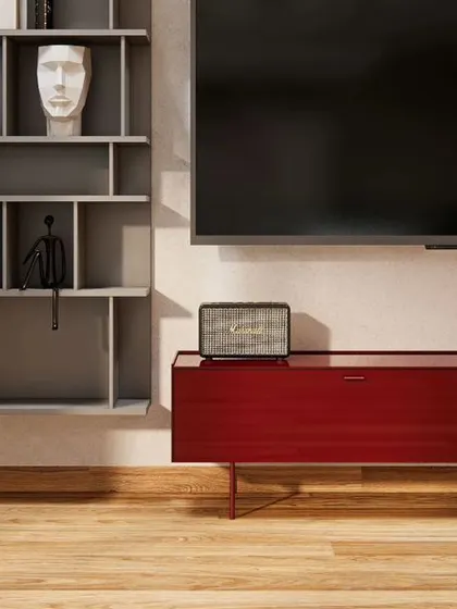 A detail of the media unit in the Renaissance Bellevue penthouse. A bold red console floats above the wooden floor, creating a pop of color in a calm, uncluttered space.