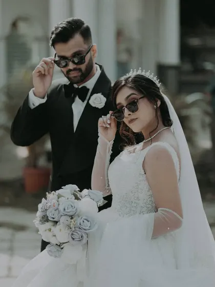 The bride and groom add a touch of modern cool with sunglasses, a fun and stylish take on the classic wedding portrait.