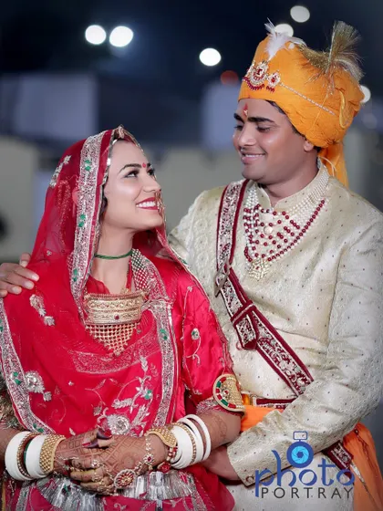 A candid moment captured between the bride and groom during their Rajasthani wedding, sharing a happy look.