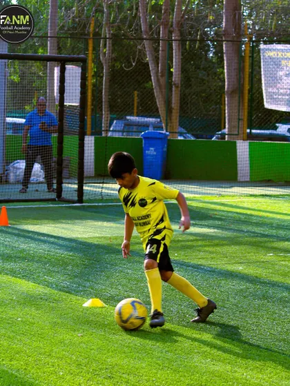 A player works on his dribbling skills during a sunny day session. I ensure my players get consistent practice to build muscle memory.