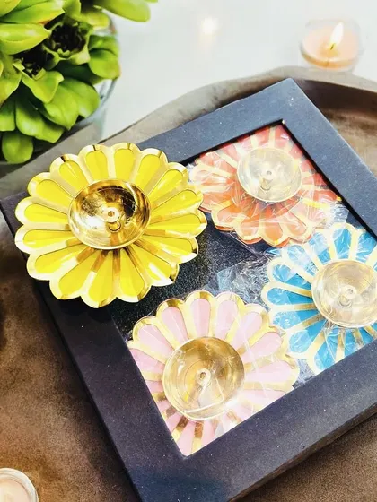 A gift set of four colorful, flower-shaped T-light holders, presented in a simple black box. This vibrant and cheerful set is an excellent and affordable token of appreciation for employees and clients.