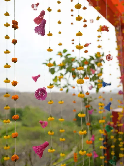 Hanging marigold strings with colorful tassels, a simple yet beautiful decor element that adds a festive touch.