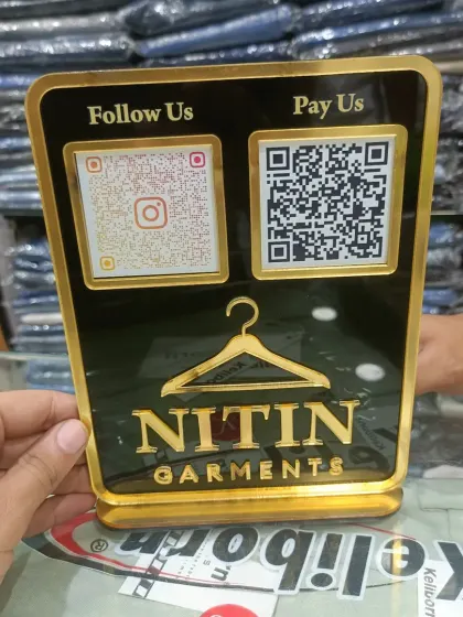 This premium acrylic QR standy, made for Nitin Garments, combines payment and social media QR codes in a sleek black and gold design. It adds a professional touch to any retail counter.