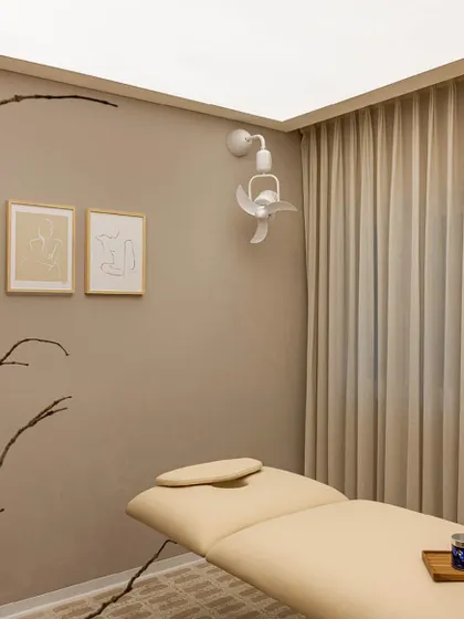 We designed the treatment rooms to be sanctuaries of calm. The space is defined by a neutral color palette, soft, indirect lighting from a stretch ceiling, and heavy curtains that ensure privacy and absorb sound, creating an ideal environment for relaxation.
