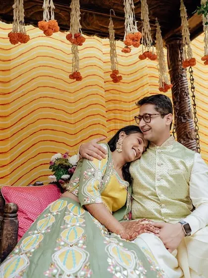 A sweet, quiet moment for the couple on a decorated swing during their Mehendi ceremony, surrounded by beautiful floral arrangements.