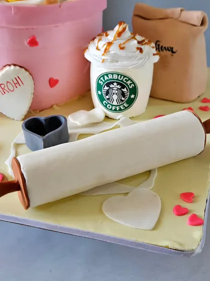 A detail shot from the baker-themed cake, showing the edible rolling pin, a bag of "flour," and a miniature Starbucks Frappuccino, complete with caramel drizzle.