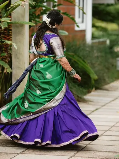 A back view of the custom-fit half saree, highlighting the rich fabrics and the way the dupatta is draped. This is a popular choice for pre-wedding festivities.