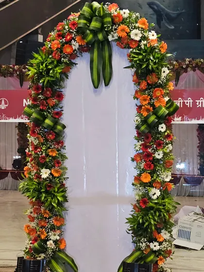 A close-up of one of the floral entrance arches. I used a vibrant mix of orange and white gerberas with intricate green leaf arrangements to create a fresh and welcoming feel for this corporate function.