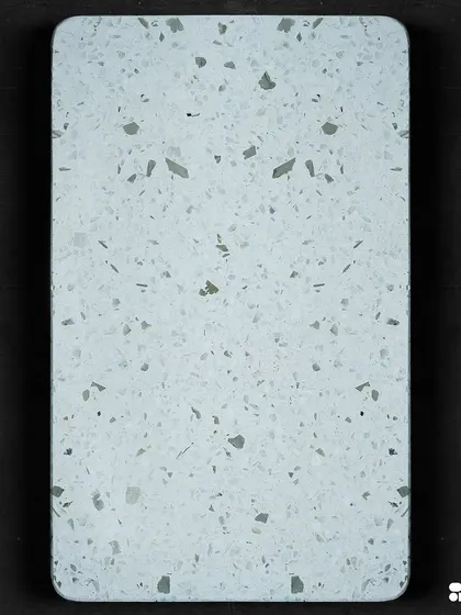 A clean and simple white terrazzo sample with subtle grey and green chips. This versatile design is perfect for creating a bright and modern space.